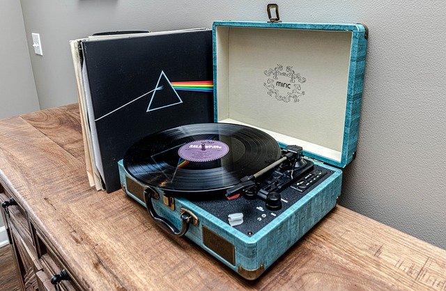 Picture of a record player on a dresser with pink floyd record next to it